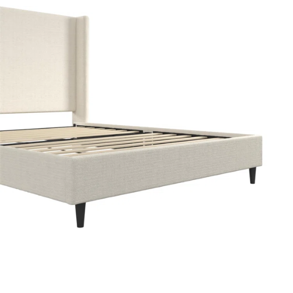 Light cream boucle queen-size platform bed with tall wingback tufted headboard and black tapered legs.

