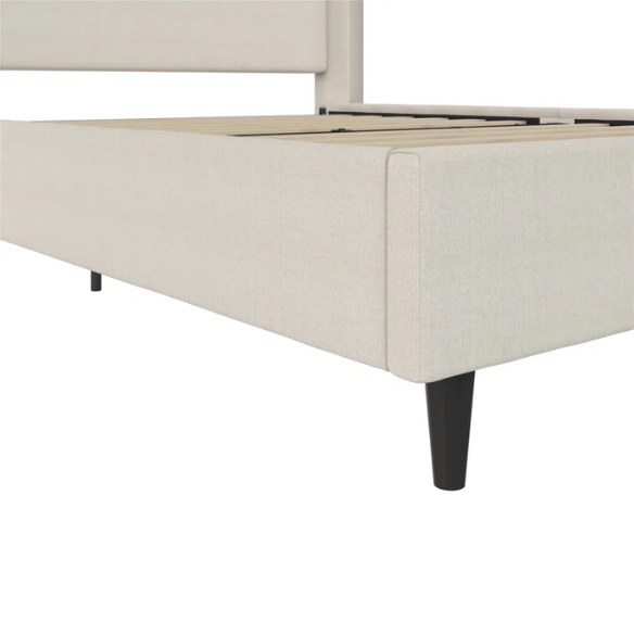 Light cream canvas upholstered queen-size bed with extra-tall wingback tufted headboard and black tapered legs.

