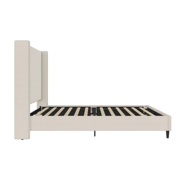 Light cream canvas upholstered queen-size bed with extra-tall wingback tufted headboard and black tapered legs.

