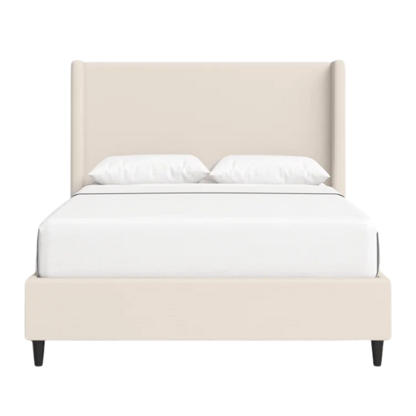 Light cream canvas upholstered queen-size bed with extra-tall wingback tufted headboard and black tapered legs.

