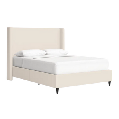 Light cream canvas upholstered queen-size bed with extra-tall wingback tufted headboard and black tapered legs.

