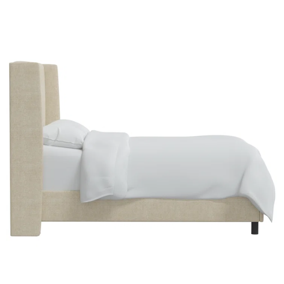 Light cream king-size upholstered bed in textured tweed fabric with wingback headboard and low-profile black metal legs.

