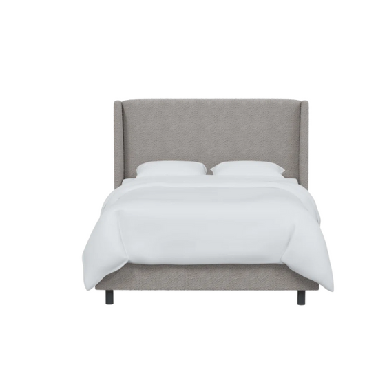Light grey king-size upholstered bed in bouclé fabric with wingback headboard and low-profile black metal legs.

