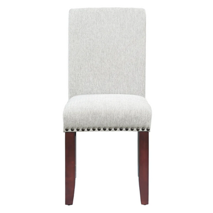 Light grey upholstered Parsons chair with scrolled high back, antique bronze nailhead trim, and solid wood legs