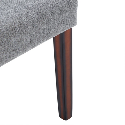 Set of 2 upholstered Parson dining chairs in light grey fabric with espresso-finished wood legs and padded high backs, ideal for dining or accent seating.

