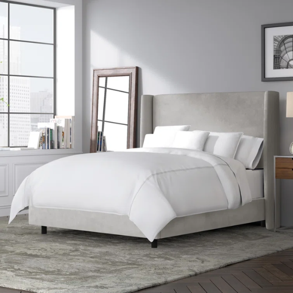 Light grey king-size upholstered bed with performance velvet fabric, wingback headboard, and low-profile black metal legs.

