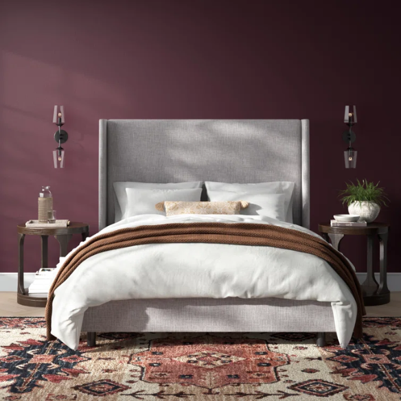 Light natural grey king-size upholstered bed in linen with wingback headboard and black metal legs.

