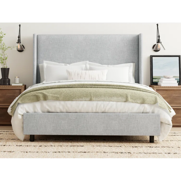 Light natural grey king-size upholstered bed in linen with wingback headboard and black metal legs.

