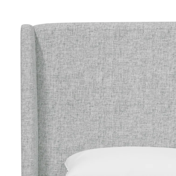 Light natural grey king-size upholstered bed in linen with wingback headboard and black metal legs.

