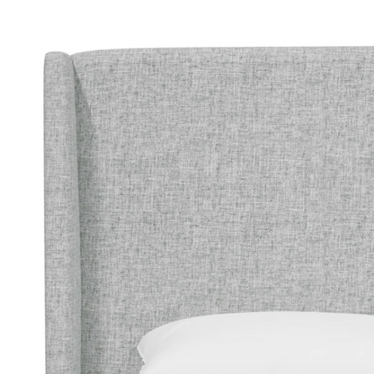 Light natural grey king-size upholstered bed in linen with wingback headboard and black metal legs.

