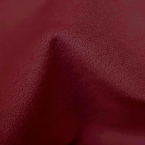 Maroon king-size upholstered bed in velvet with wingback headboard and low-profile black metal legs.

