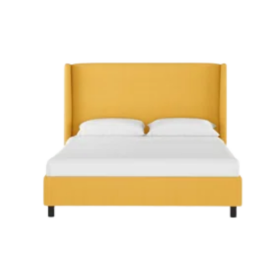 Mustard yellow king-size upholstered bed in linen fabric with wingback headboard and low-profile black metal legs.

