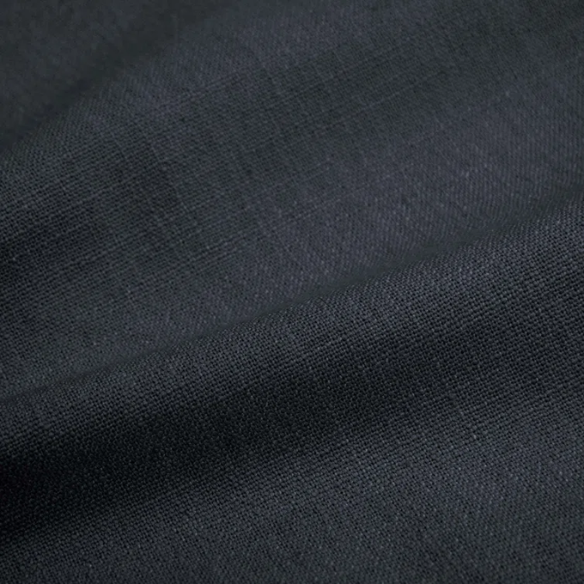 Navy blue king-size upholstered bed in linen fabric with wingback headboard and low-profile black metal legs.

