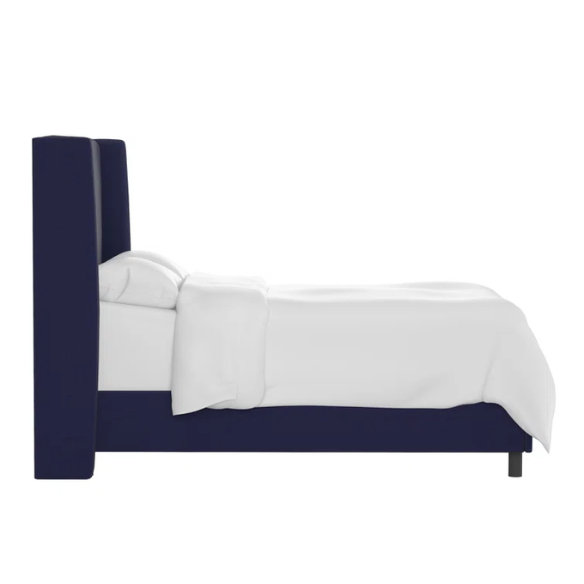 Navy blue king-size upholstered bed in twill fabric with wingback headboard and low-profile black metal legs.

