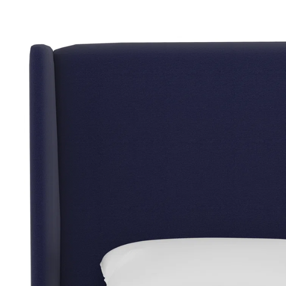 Navy blue king-size upholstered bed in twill fabric with wingback headboard and low-profile black metal legs.

