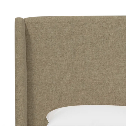 Neutral tan king-size upholstered bed in linen fabric with wingback headboard and black metal legs.

