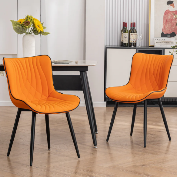 Set of 2 orange and black dining chairs with faux leather fishtail backs and metal legs, perfect for modern and contemporary interiors.

