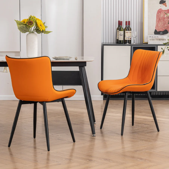Set of 2 orange and black dining chairs with faux leather fishtail backs and metal legs, perfect for modern and contemporary interiors.

