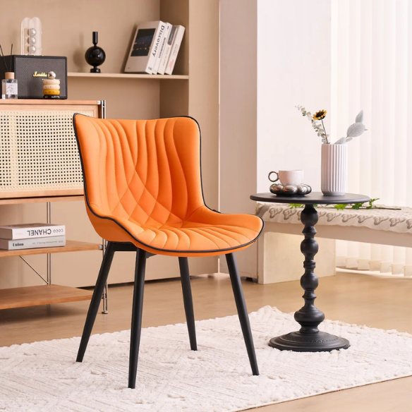Set of 2 orange and black dining chairs with faux leather fishtail backs and metal legs, perfect for modern and contemporary interiors.

