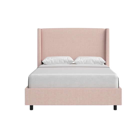 Rosy pink king-size upholstered bed in linen with wingback headboard and black metal legs.

