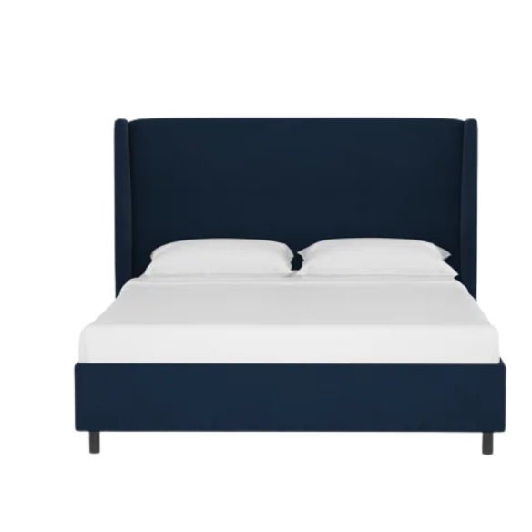 Royal blue king-size upholstered bed in velvet fabric with wingback headboard and low-profile black metal legs.

