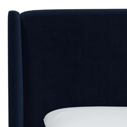 Royal blue king-size upholstered bed in velvet fabric with wingback headboard and low-profile black metal legs.

