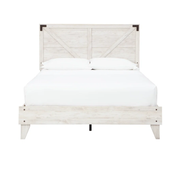 Rustic white platform bed with a distressed finish, crossbuck headboard, and metal support slats, styled in a cozy farmhouse bedroom.

