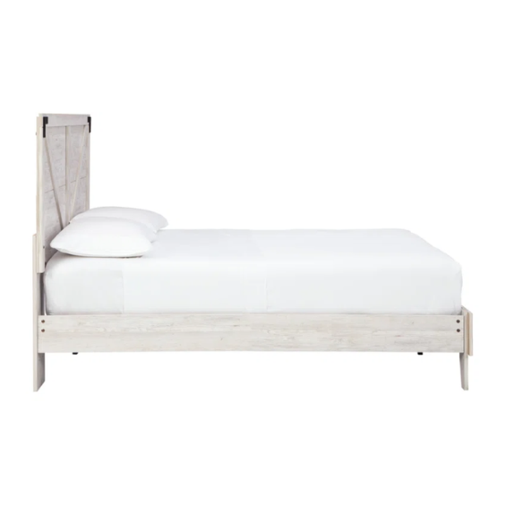 Rustic white platform bed with a distressed finish, crossbuck headboard, and metal support slats, styled in a cozy farmhouse bedroom.


