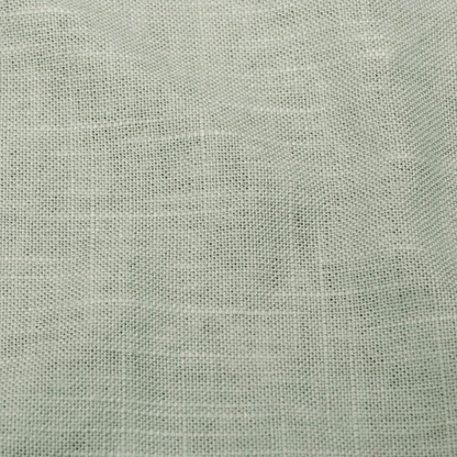 Sage green king-size upholstered bed in linen fabric with wingback headboard and low-profile black metal legs.

