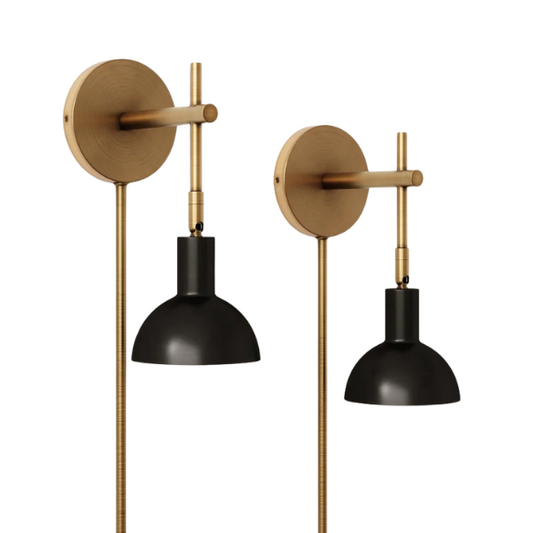 Set of two black and brass plug-in wall sconces with adjustable swing arms and brass bell-shaped shades, featuring on/off cord switch and matching black cord covers

