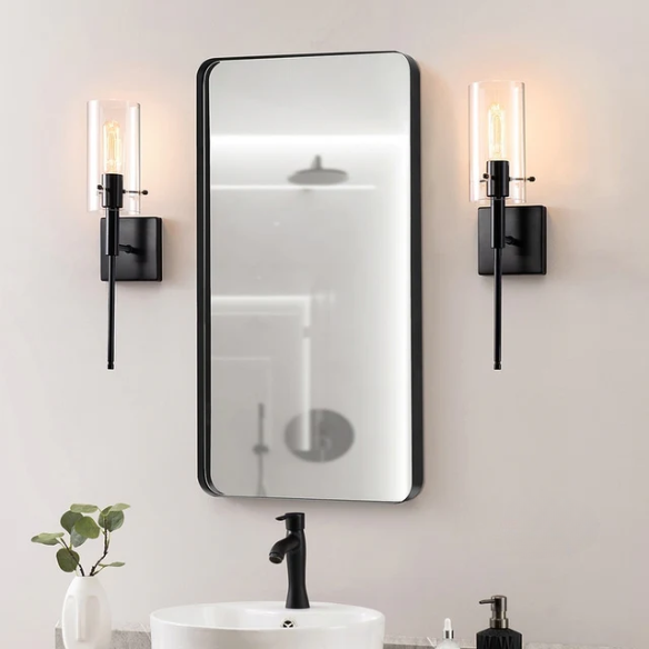 Set of 2 black wall sconces with hand-blown glass cylinder shades and bronze hardware, mountable up or down for modern or farmhouse interiors

