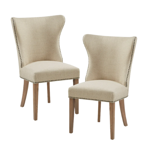 Set of two cream upholstered dining chairs with curved wingback design, dark pewter nailhead trim, and latte wood legs in a traditional style