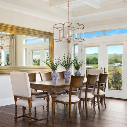 Mid-century modern brass drum chandelier with four candelabra lights in an open lantern frame, ideal for farmhouse and transitional interiors.

