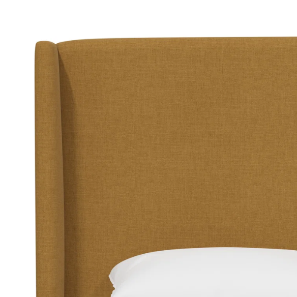 Warm golden king-size upholstered bed in linen fabric with wingback headboard and black metal legs.

