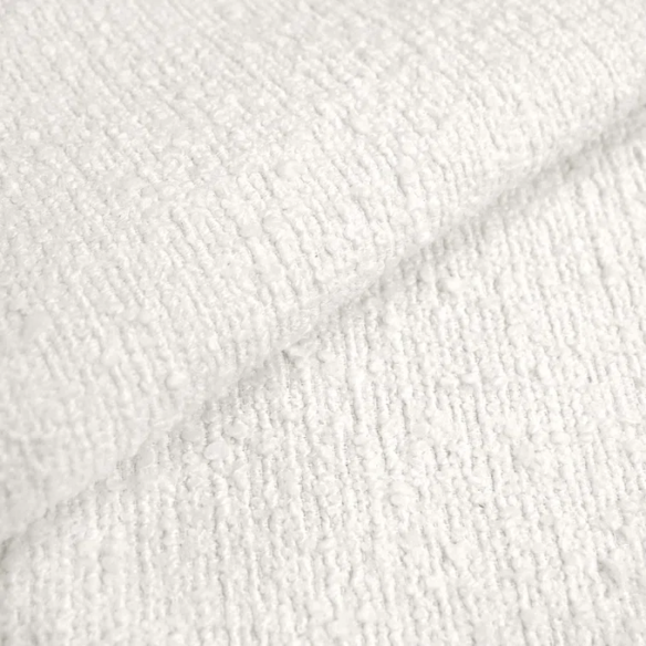 White king-size upholstered bed in bouclé fabric with wingback headboard and low-profile black metal legs.

