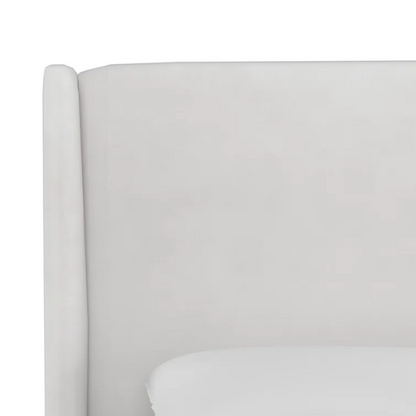 White king-size upholstered bed in velvet fabric with wingback headboard and low-profile black metal legs.

