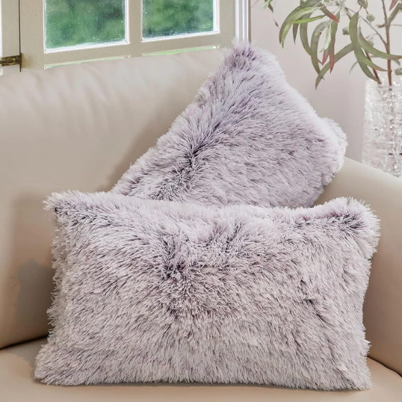 Set of two purple and white ombré faux fur throw pillows with plush texture on a modern neutral-toned couch

