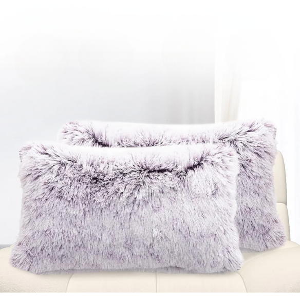 Set of two purple and white ombré faux fur throw pillows with plush texture on a modern neutral-toned couch

