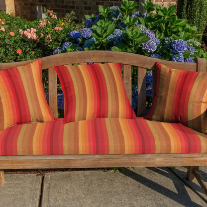 Striped accent pillow in red, orange, and brown – reversible, weather-resistant, and overstuffed for cozy indoor or outdoor décor.

