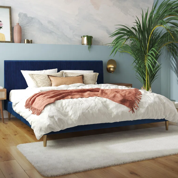 Royal blue velvet king platform bed with tufted rectangular headboard, wood slat support, and sleek low-profile design.

