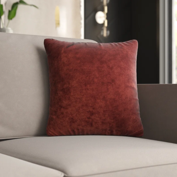 Rust crushed velvet throw pillow, 16x16 square design with soft texture and reversible fabric, styled on a modern sofa for cozy and elegant home decor.

