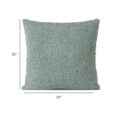 Seafoam green bouclé throw pillow with soft looped texture, square accent pillow on a neutral sofa

