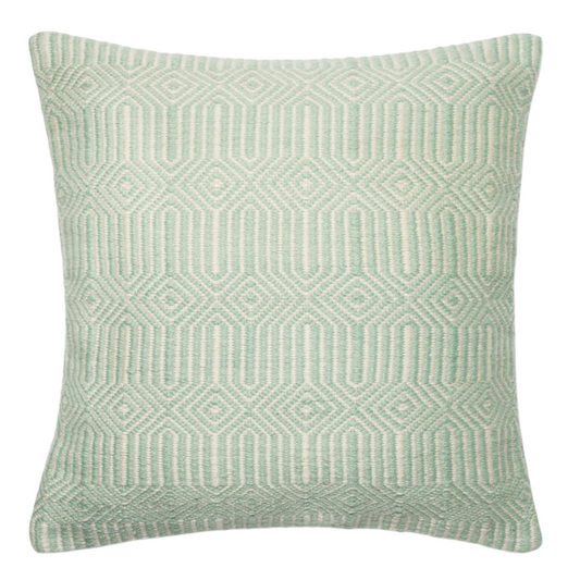 Seafoam green and cream geometric throw pillow on an outdoor patio chair with modern decor

