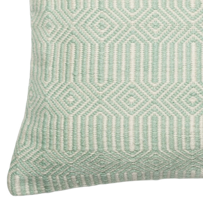 Seafoam green and cream geometric throw pillow on an outdoor patio chair with modern decor

