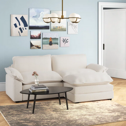 Soft warm cream modular cloud sofa with deep foam cushions, pillow top arms, and a matching free-standing ottoman