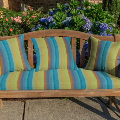 Striped accent pillow in teal, lime green, blue, and orange – reversible, weather-resistant, and overstuffed for indoor and outdoor comfort on patios, porches, or couches.

