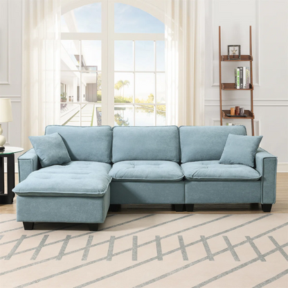 Tranquil sea blue suede L-shaped sectional sofa with tufted seat cushions, reversible chaise, removable ottoman, and two matching throw pillows