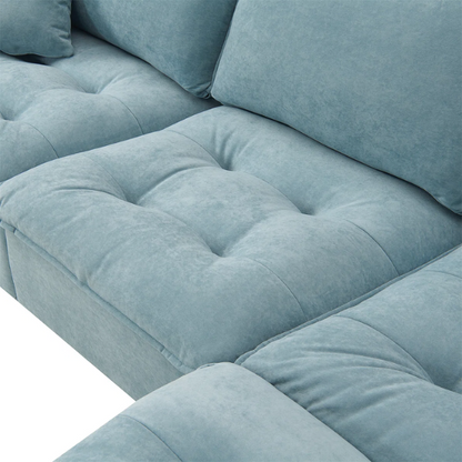 Tranquil sea blue suede L-shaped sectional sofa with tufted seat cushions, reversible chaise, removable ottoman, and two matching throw pillows