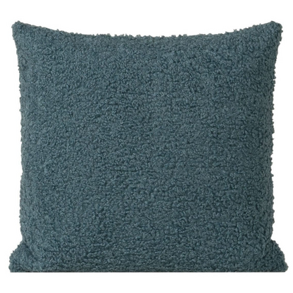 Turquoise bouclé throw pillow with textured loop fabric, square accent pillow on a modern sofa


