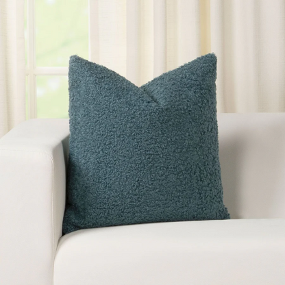 Turquoise bouclé throw pillow with textured loop fabric, square accent pillow on a modern sofa

